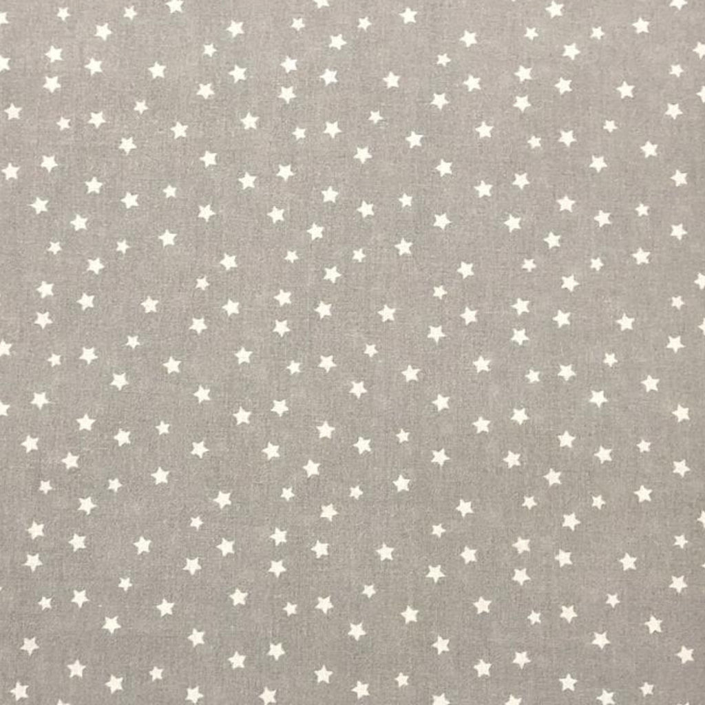 Mantel infantil gris con estrellas extendido en mesa de juego